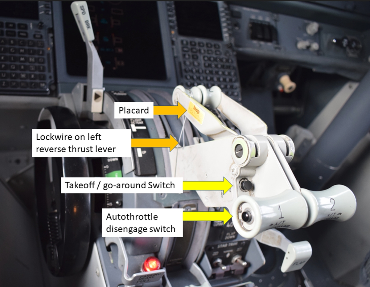 Figure 1. The layout of the control stand in the occurrence aircraft, showing the lockwired left reverse thrust lever, placard, takeoff/go-around switch, and autothrottle disengage switch (Source: TSB)